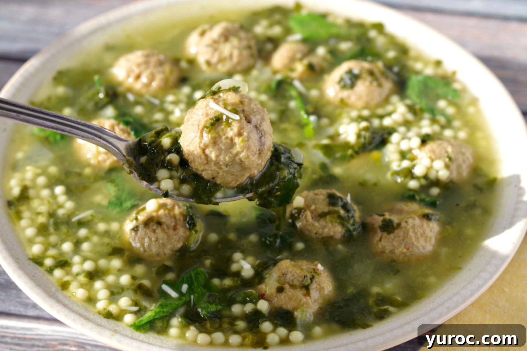 Bowl of Easy Italian Wedding Soup with meatball on spoon