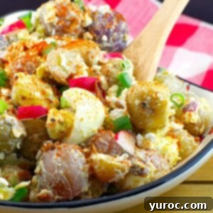 Signature Pierogi Potato Salad 17 Pierogi Potato salad in a Ukrainian print dish with wooden spoon and checkered red and white towel in the background