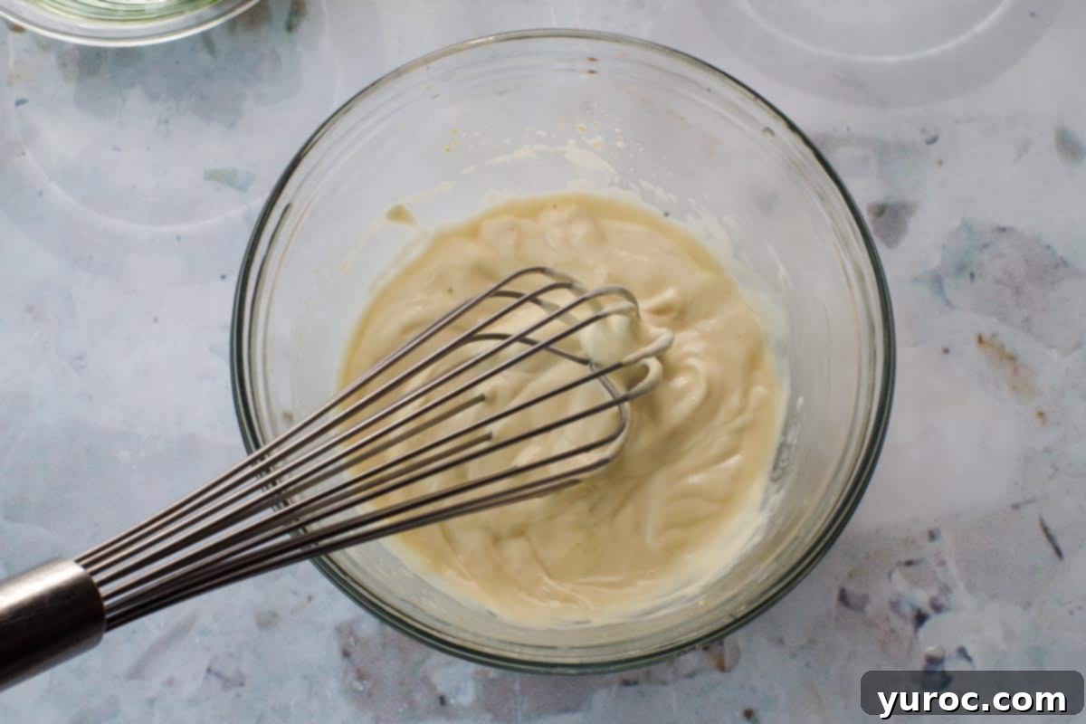 Signature Pierogi Potato Salad 9 Mayonnaise, sauerkraut liquid and Dijon mustard whisked together in a glass bowl.
