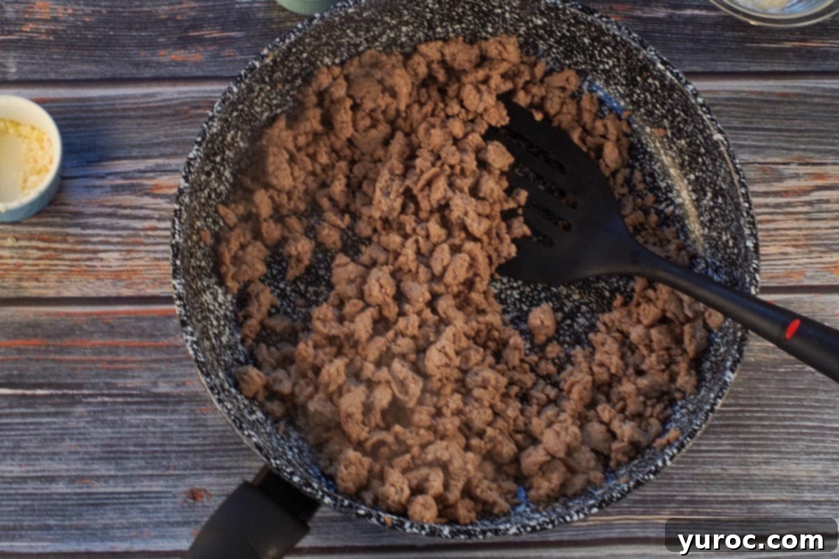 Smart Turkey Shepherd's Pie 6 Cooked lean ground turkey in a frying pan with a spatula, ready to be drained.