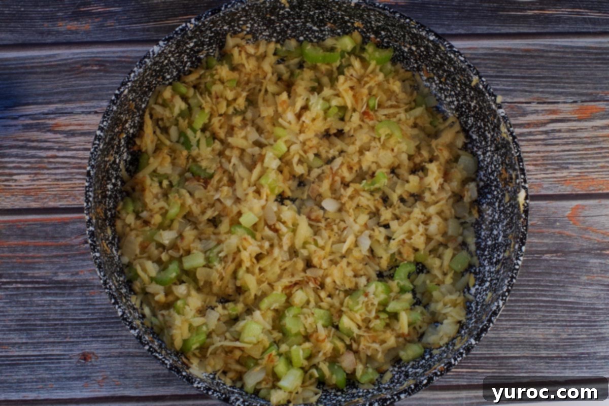 Smart Turkey Shepherd's Pie 7 Diced onions, celery, and grated parsnips sautéing in a frying pan, releasing their aromatic flavors.