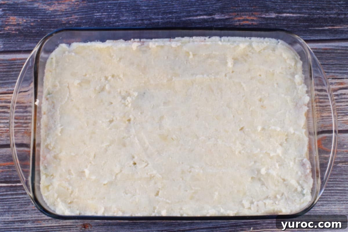 Smart Turkey Shepherd's Pie 10 Turkey mixture completely topped with the creamy mashed potato mixture in a glass 9x13 dish, ready for baking.