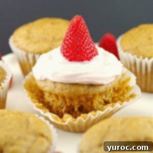 Pancake cupcake with Greek yogurt and strawberry topping, on loosened muffin liner wrapper, with other cupcake pancakes around it