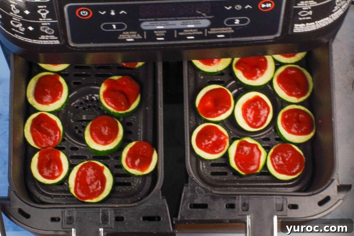 Zucchini bites topped with a thin layer of pizza sauce.