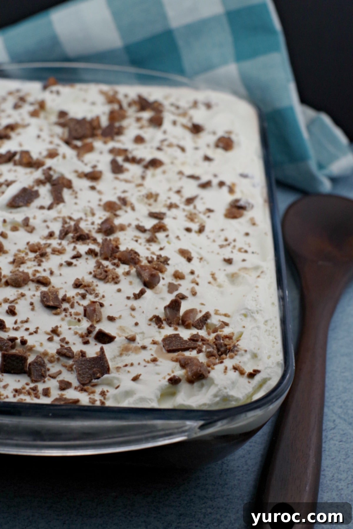 Skor Toffee Crunch Bars 6 skor dessert in glass pan garnished with crushed up skor bits, ready to be served.