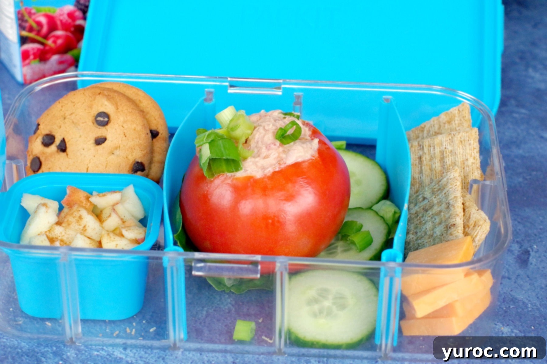 stuffed tomatoes in lunch box with cracker, cheese, cookies and apple yogurt