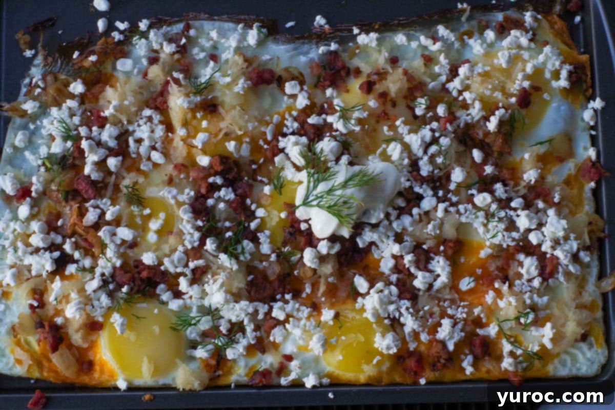 Baked Ukrainian style eggs on a sheet pan, topped with various ingredients.