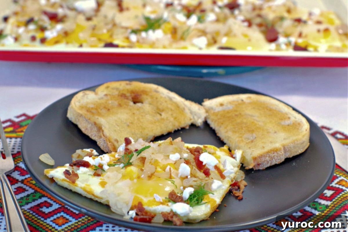 A plate of sheet pan Ukrainian style eggs in the foreground, with the full sheet pan in the background.
