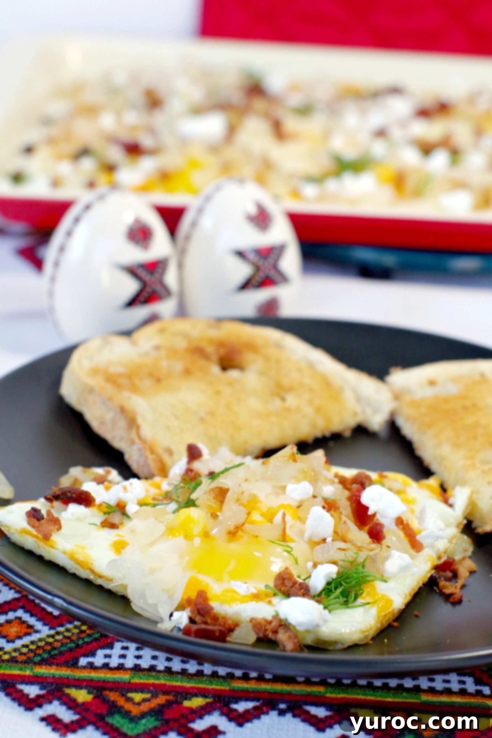 A plate of sheet pan Ukrainian style eggs with a larger sheet pan of eggs in the background.