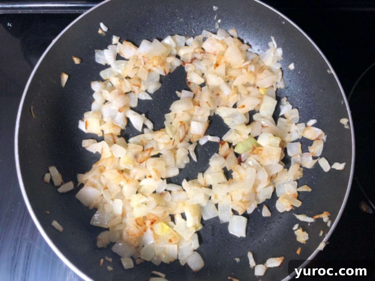 Chopped onions frying in butter in a pan until lightly browned.