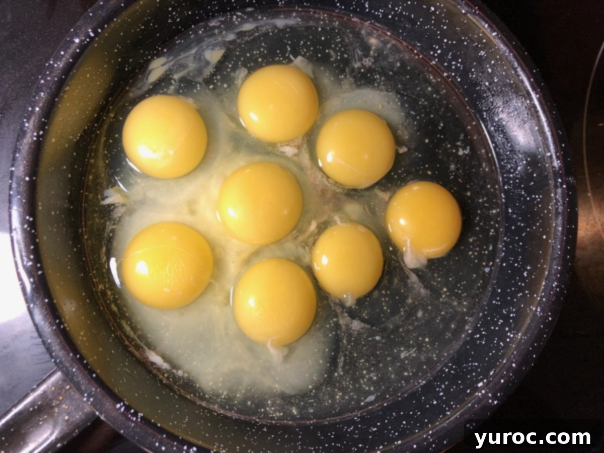 Raw eggs carefully cracked into a separate frying pan.