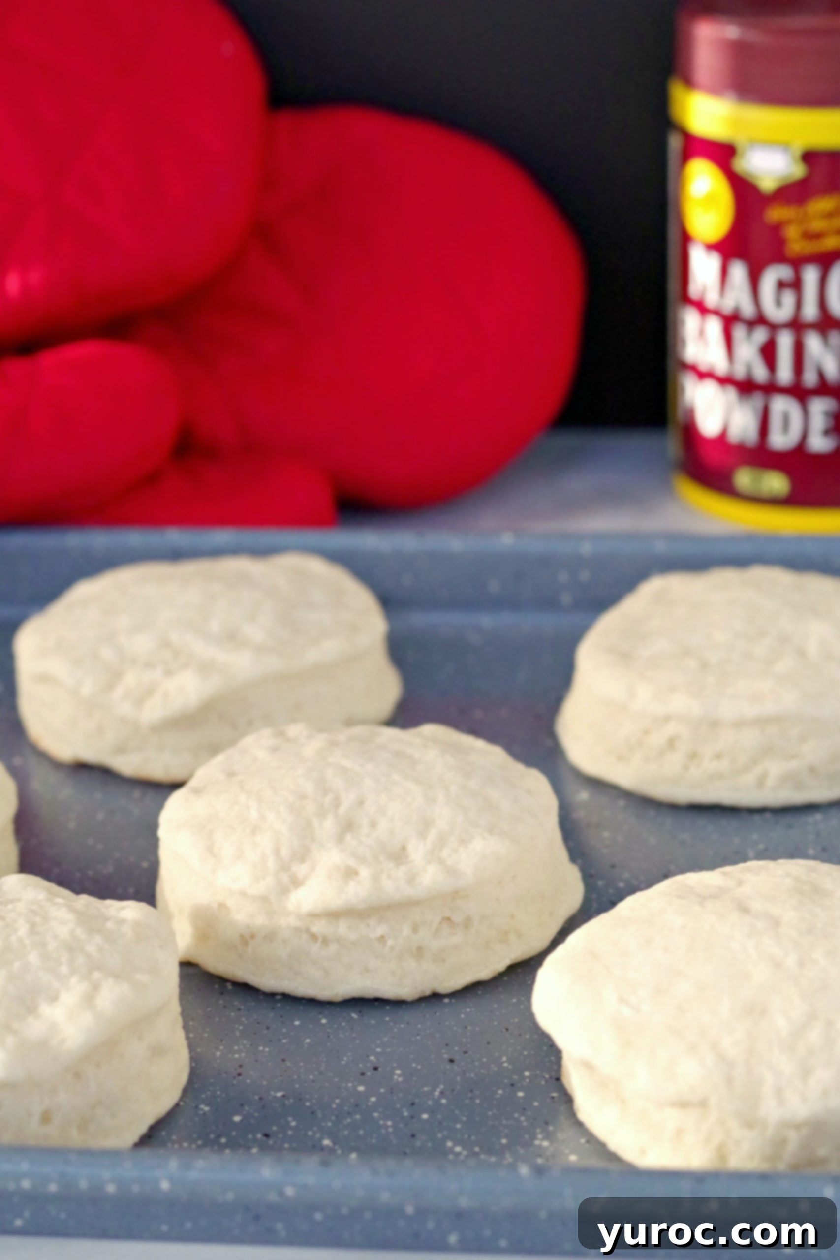 A stack of golden-brown baking powder biscuits, ready to be served. This image emphasizes the light and airy texture achieved with shortening and cream of tartar, rather than butter.