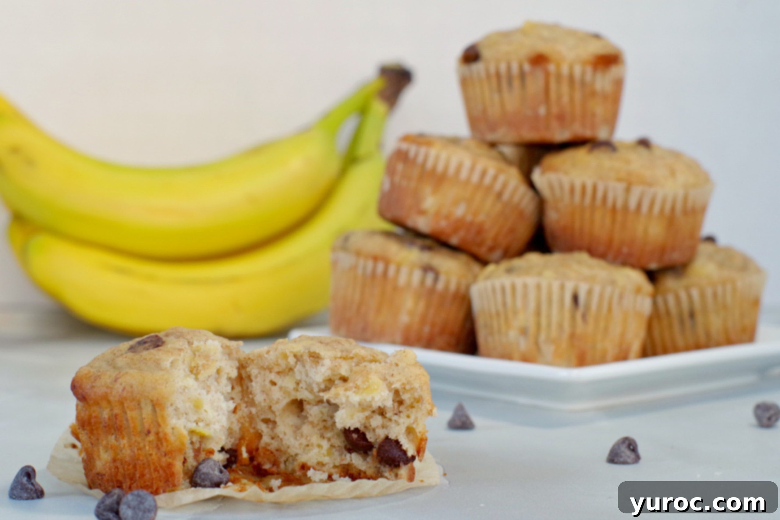 Wholesome Banana Pineapple Chocolate Chip Muffins 3 Muffin split in half in front with plate of muffins piled up in background