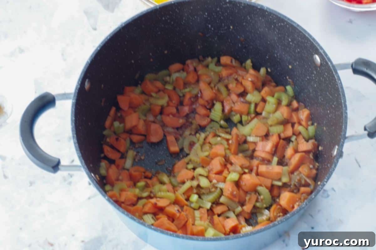 carrots and celery added to onions and garlic in soup pot
