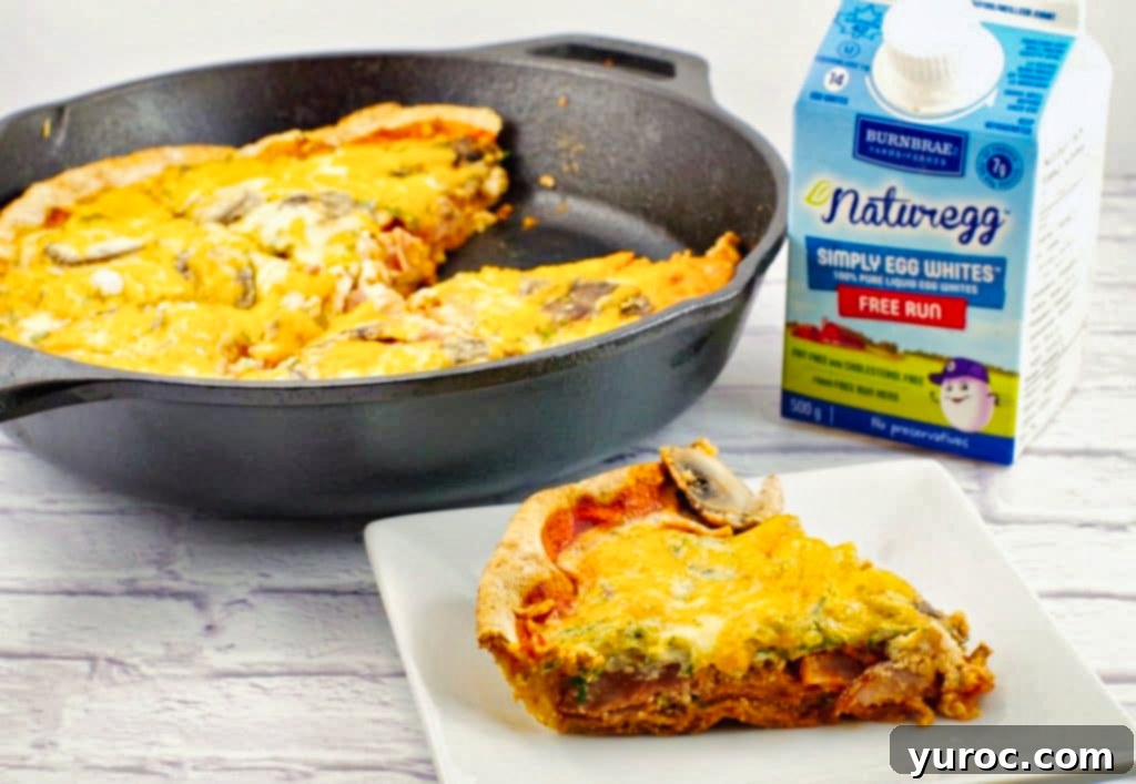 egg white breakfast pizza on a white plate, with cast iron frying pan in background and container of liquid egg whites