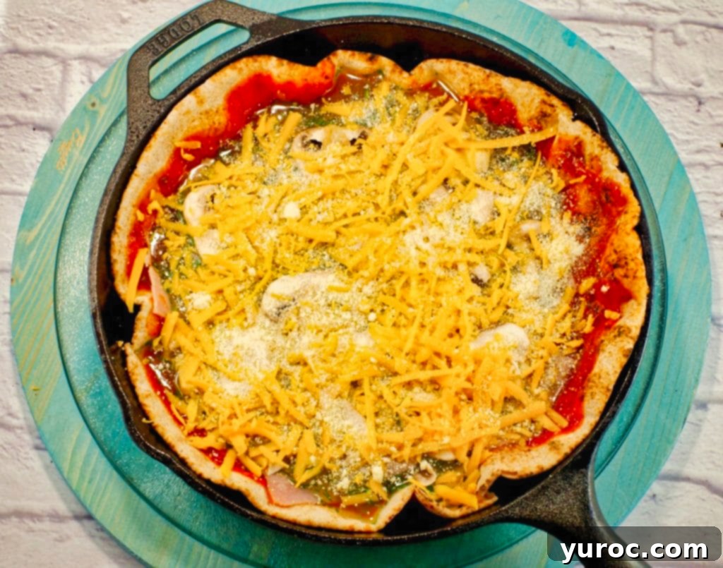 Cheese added to egg white pizza in cast iron frying pan