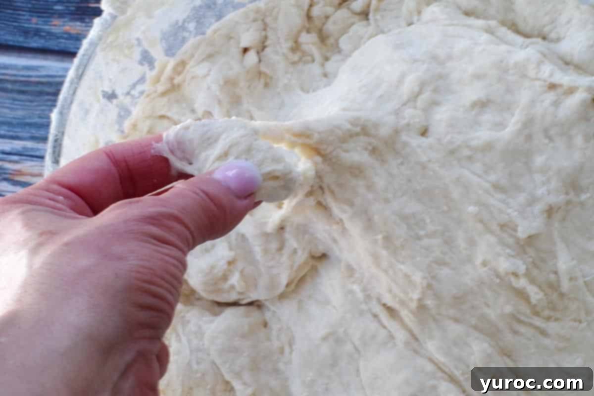 A finger gently pressing into the dough to check its texture and stickiness