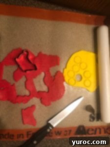 Using mini cookie cutters to create fondant decorations for the snow globe treats.