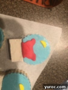 Attaching fondant decorations to the Rice Krispie Snow Globes with a dab of corn syrup.