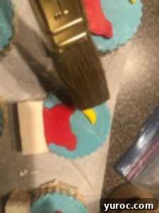 Applying confectioners glaze to the Snow Globe Rice Krispie Treats for a glossy finish.
