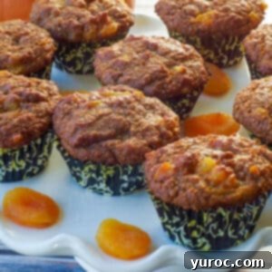 healthy bran pumpkin muffins on a white cake platter with dried apricots