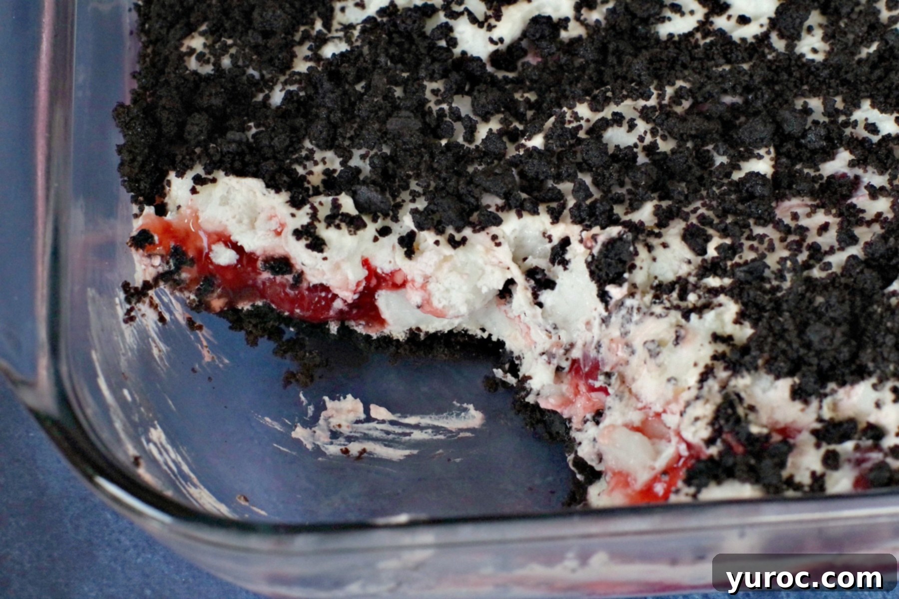 Close-up of Cherry Cha Cha dessert showcasing its distinct layers of cookie crumbs, whipped cream, and cherry filling.