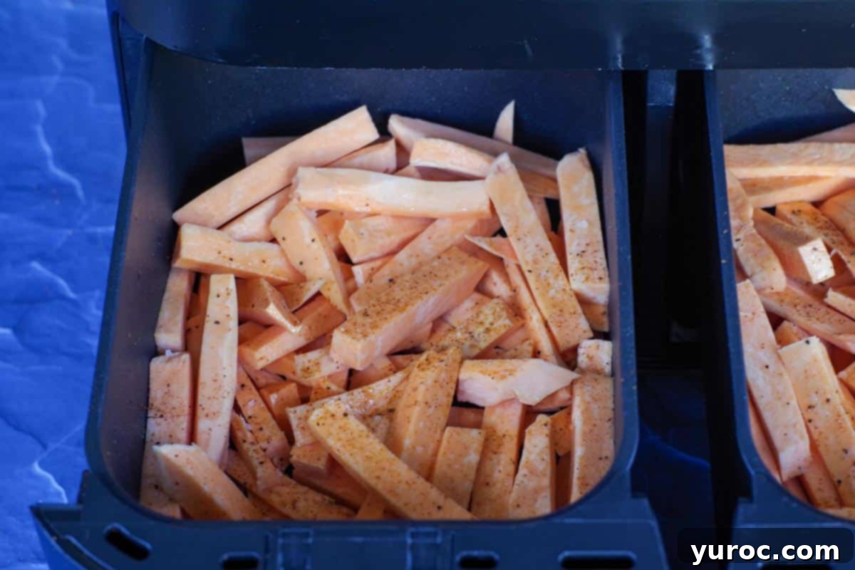 raw sweet potato fries in a drawer of air fryer