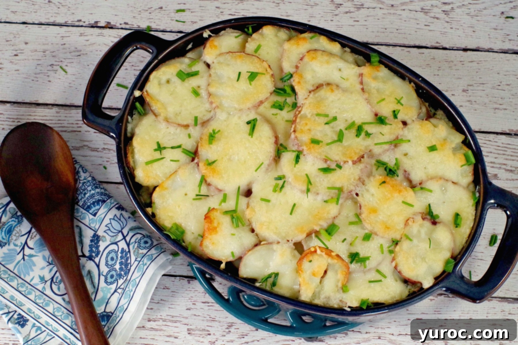 Hearty Potato and Ground Beef Casserole with Spinach, bubbly and golden in a blue casserole dish, ready to serve.