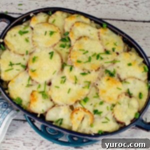 Potato casserole with spinach and beef in blue casserole dish, showcasing a perfect slice of this hearty meal.