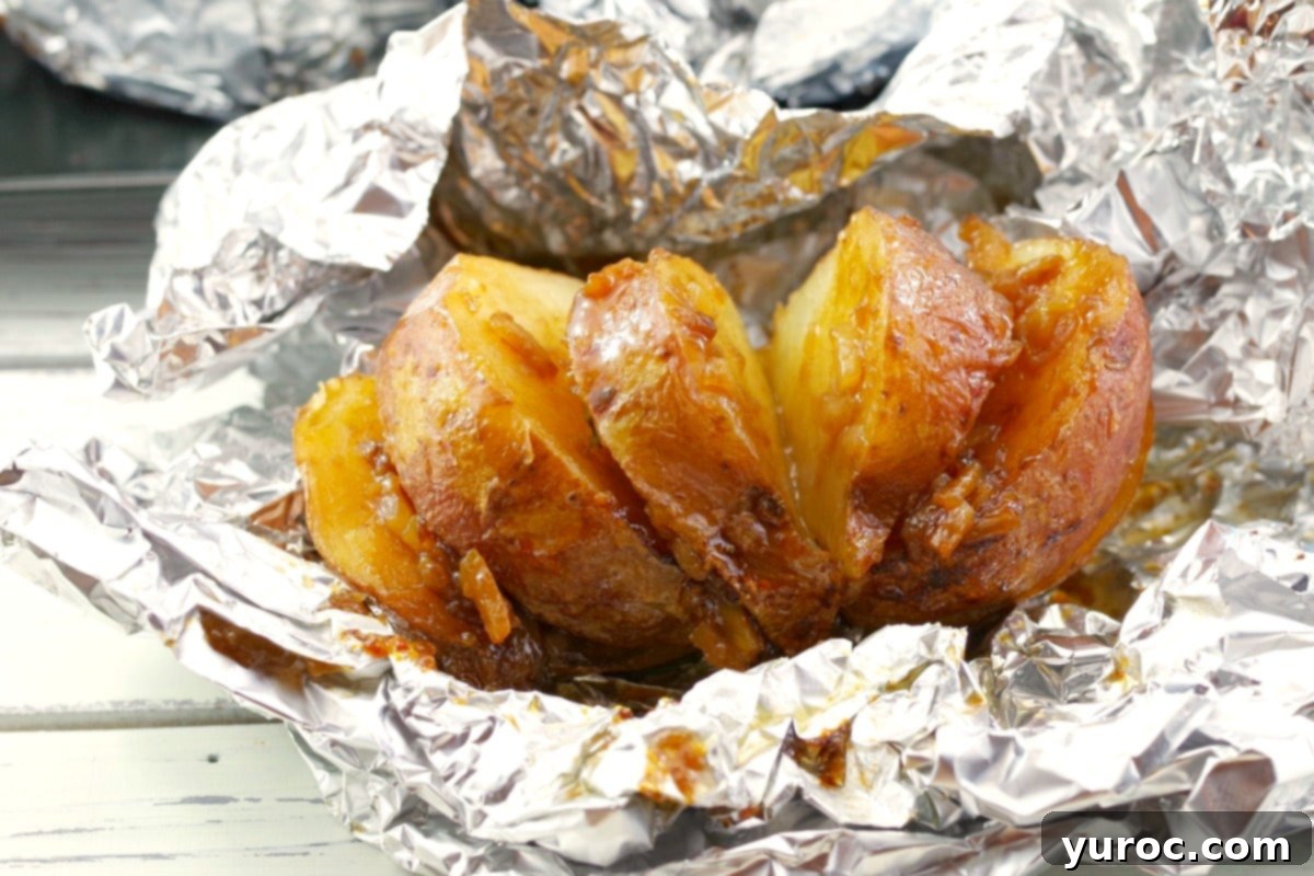 Baked potatoes wrapped in foil, next to a bowl of onion soup mix, illustrating a common but often unnecessary cooking method.