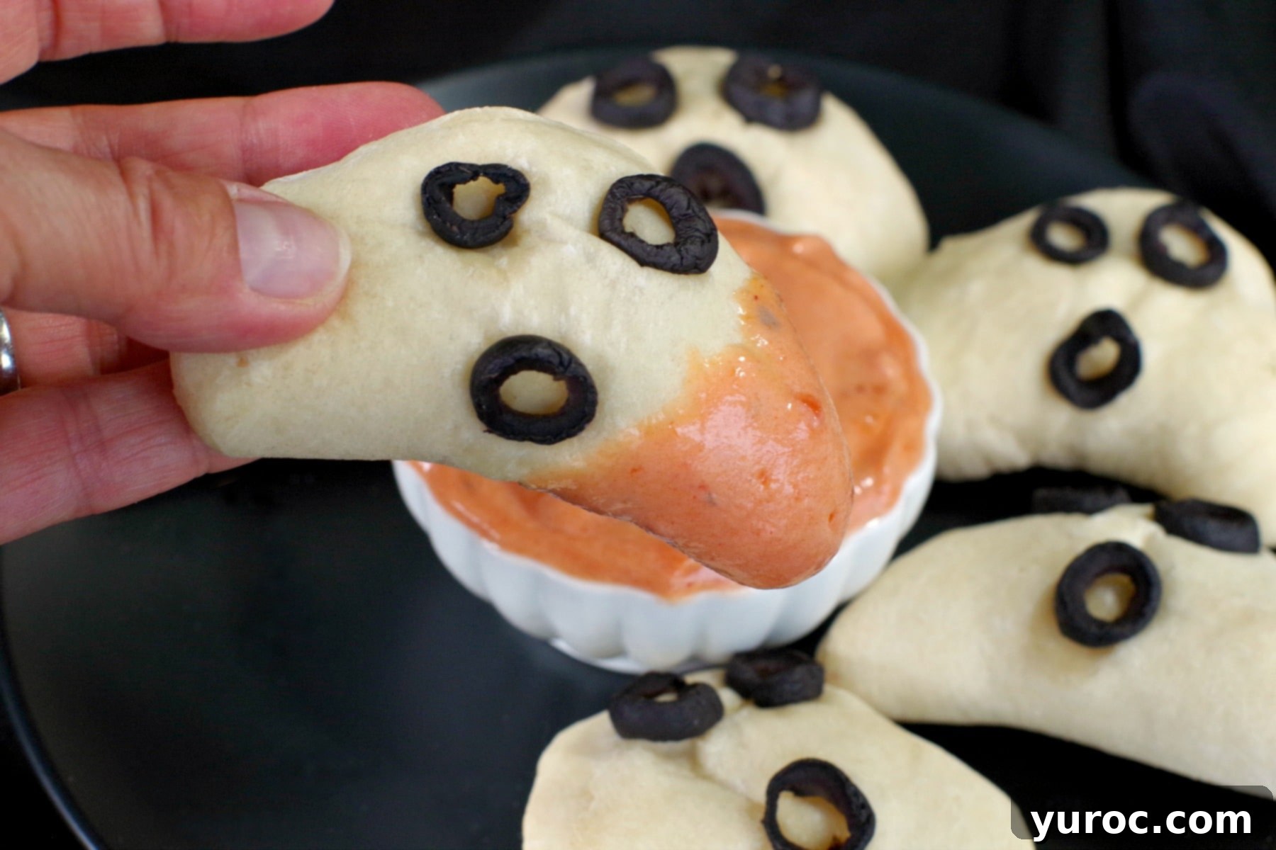 Halloween Phantom Pierogi Mini Pizza Pockets being dipped into sour cream pizza dip