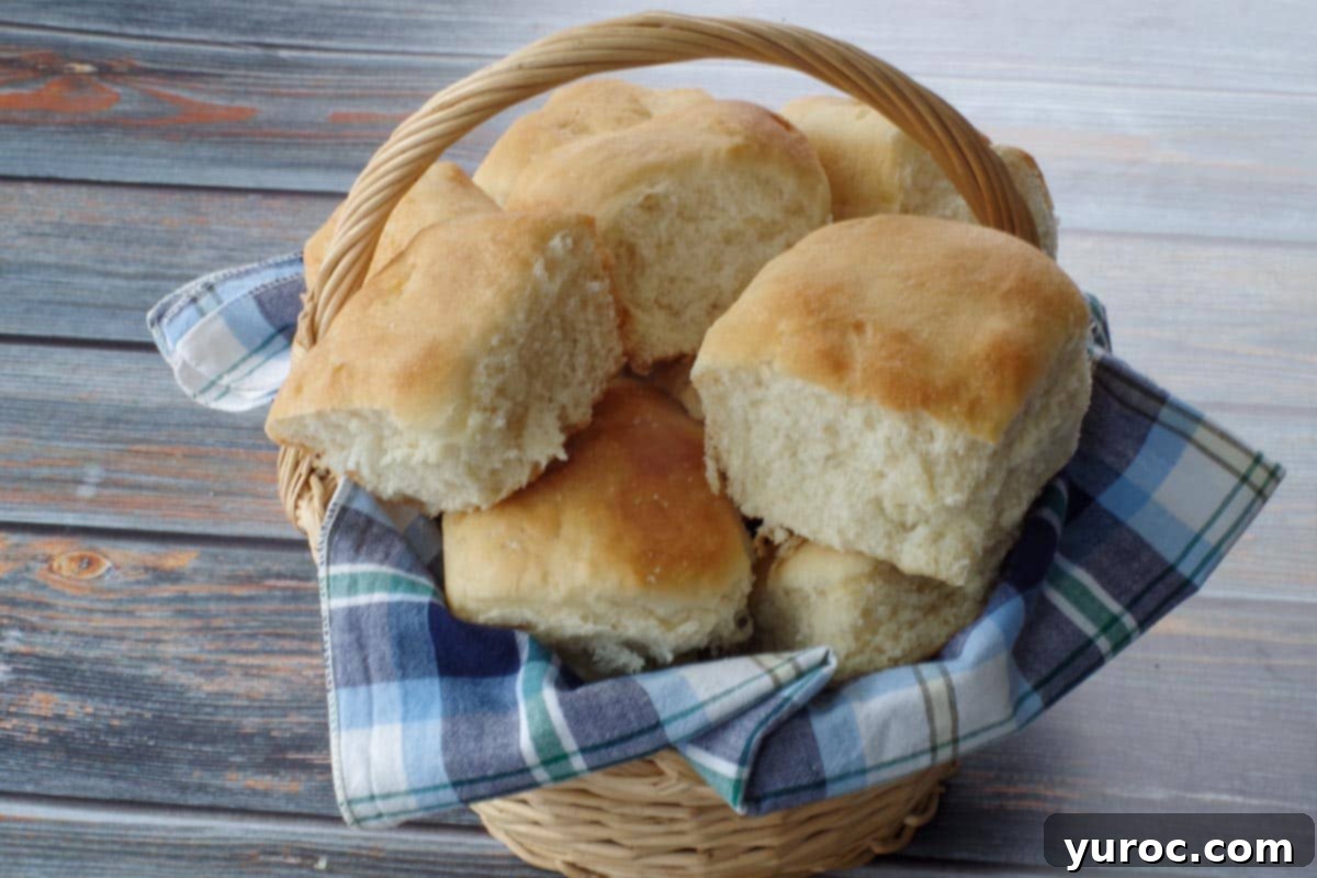 Homestyle Hamburger Potato Soup 9 A basket filled with several golden-brown Grandma Buns, resting on a blue checked cloth, ready to be served with soup.