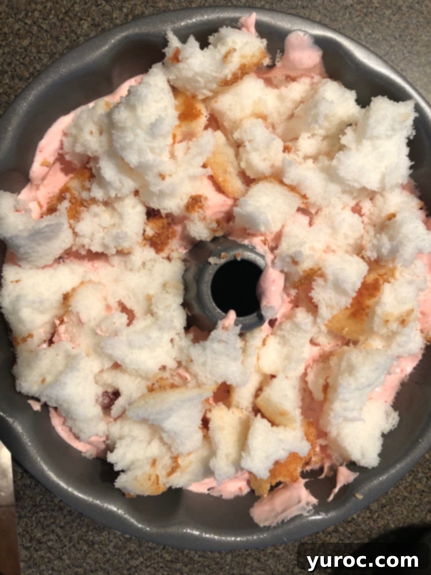½ jello/whipped cream mixture added, then next layer of angel food cake bits