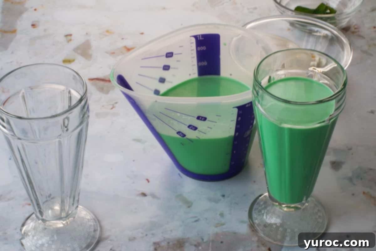 Emerald Grasshopper Mocktail 7 A large measuring cup partly filled with green grasshopper mocktail, ready to be poured into glasses.