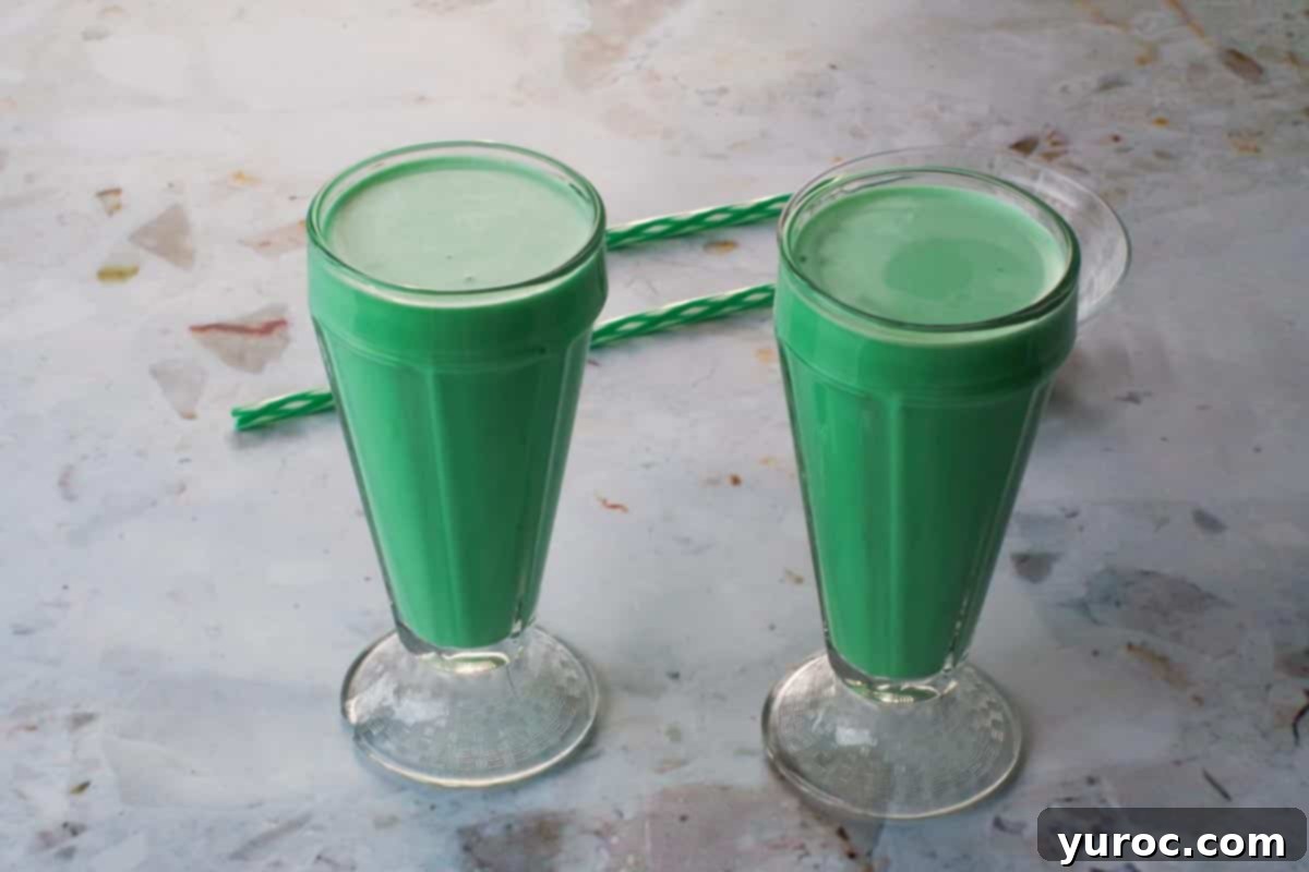 Emerald Grasshopper Mocktail 8 Two milkshake glasses filled with Green Grasshopper Mocktail, ready for garnish.