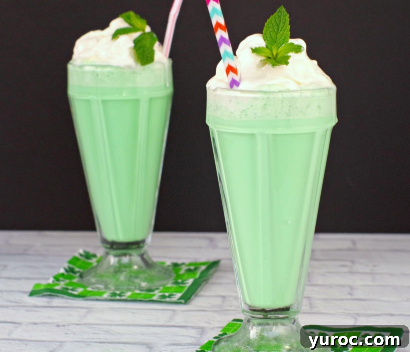 Emerald Grasshopper Mocktail 10 Two vibrant green Grasshopper Mocktails presented on festive shamrock napkins, perfect for St. Patrick's Day.