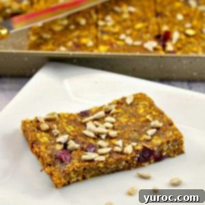 Healthy Fruit and Oat Bars on white plate with pan of more in the background