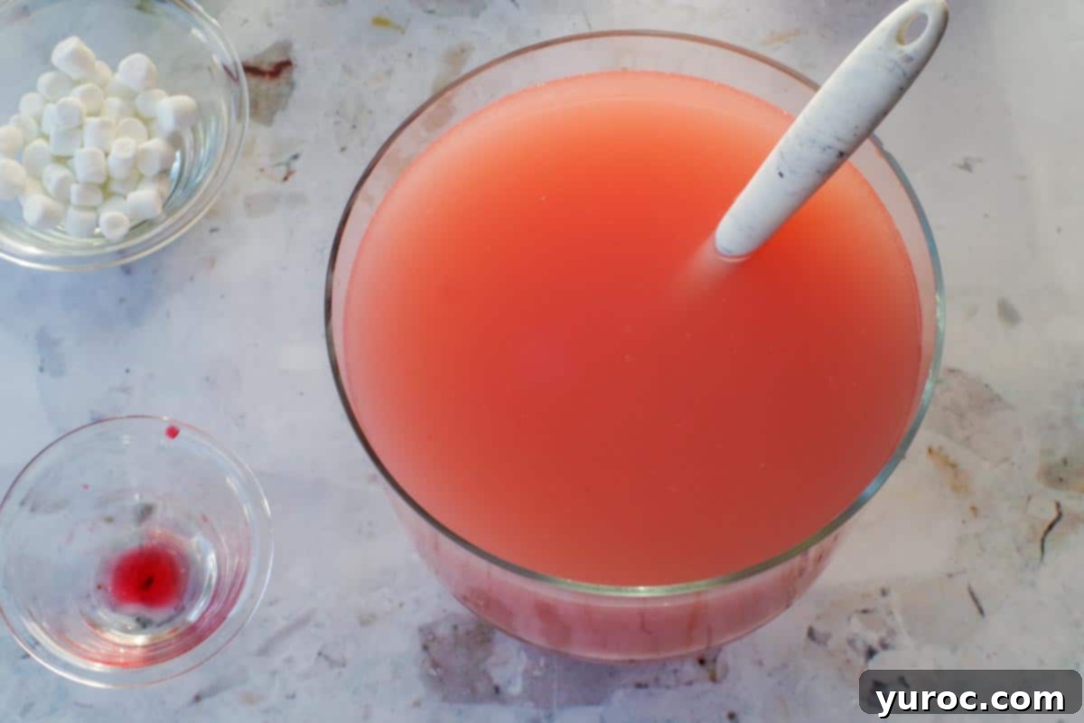 Grenadine added to pina colada mixture and stirred with a marble silicone spoon.