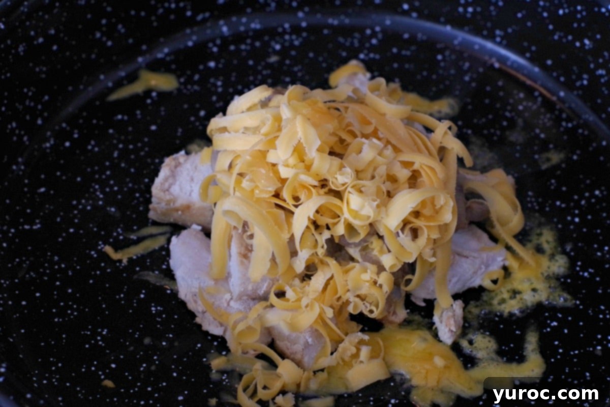 cheese grated onto sauteed mushrooms on diced chicken breast