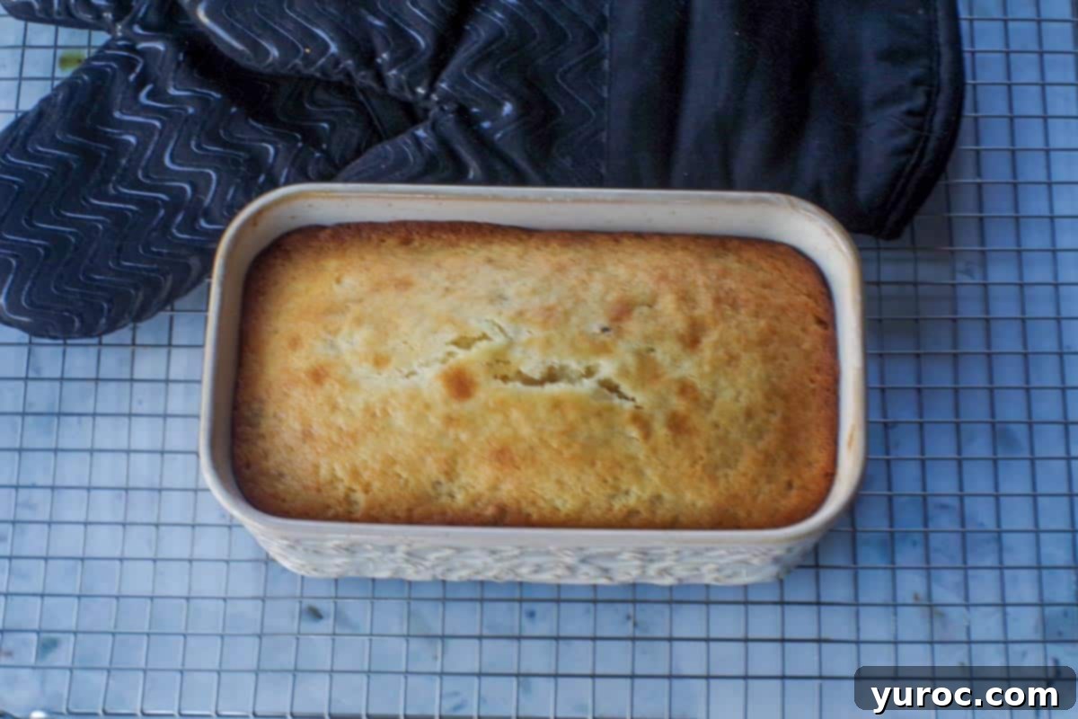 Freshly baked lemon bread cooling on a wire rack after being removed from the pan