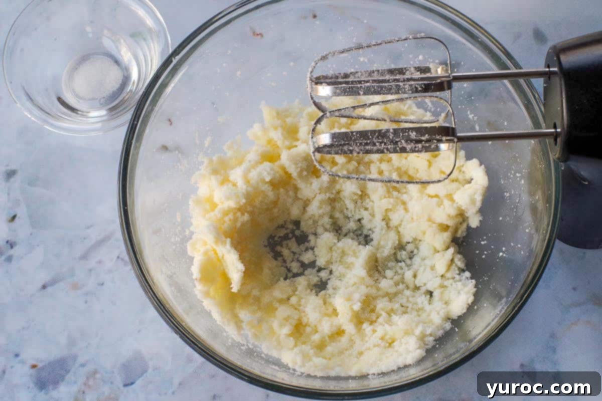 Creaming butter and sugar together in a large glass bowl with an electric mixer