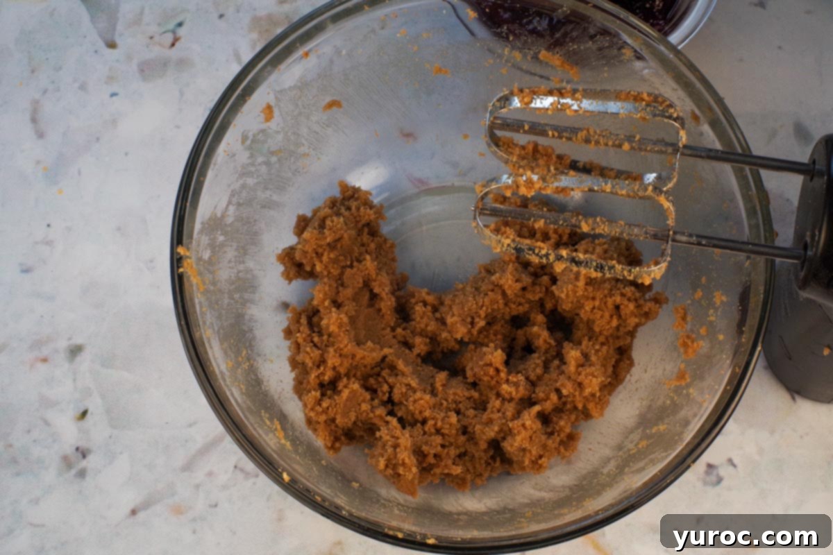 Brown Sugar and Butter beaten together in large glass bowl, with beaters over bowl.
