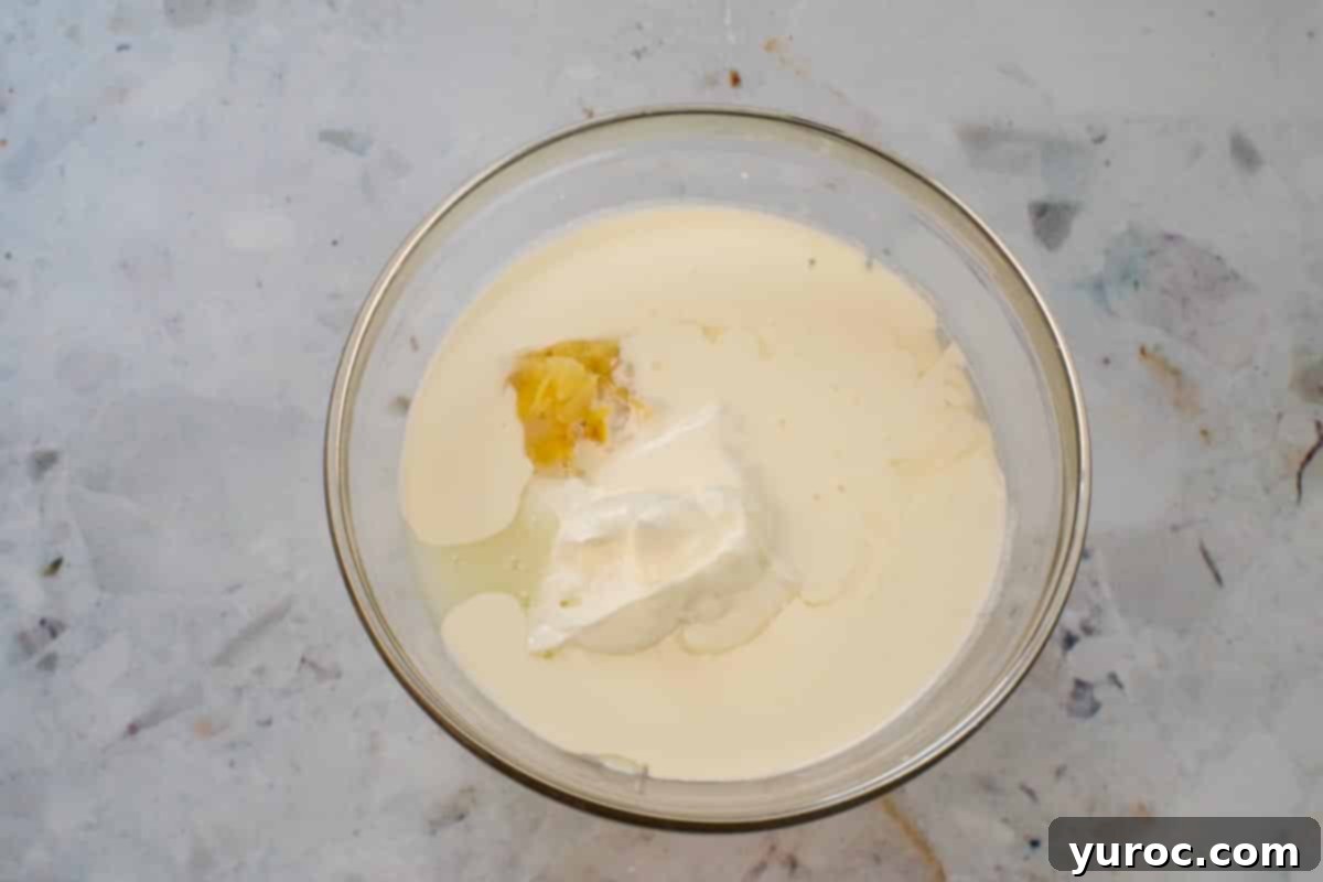 Cool & Creamy Virgin Pina Colada Pops 5 All Piña Colada popsicle ingredients gathered in a large glass bowl, ready for mixing.