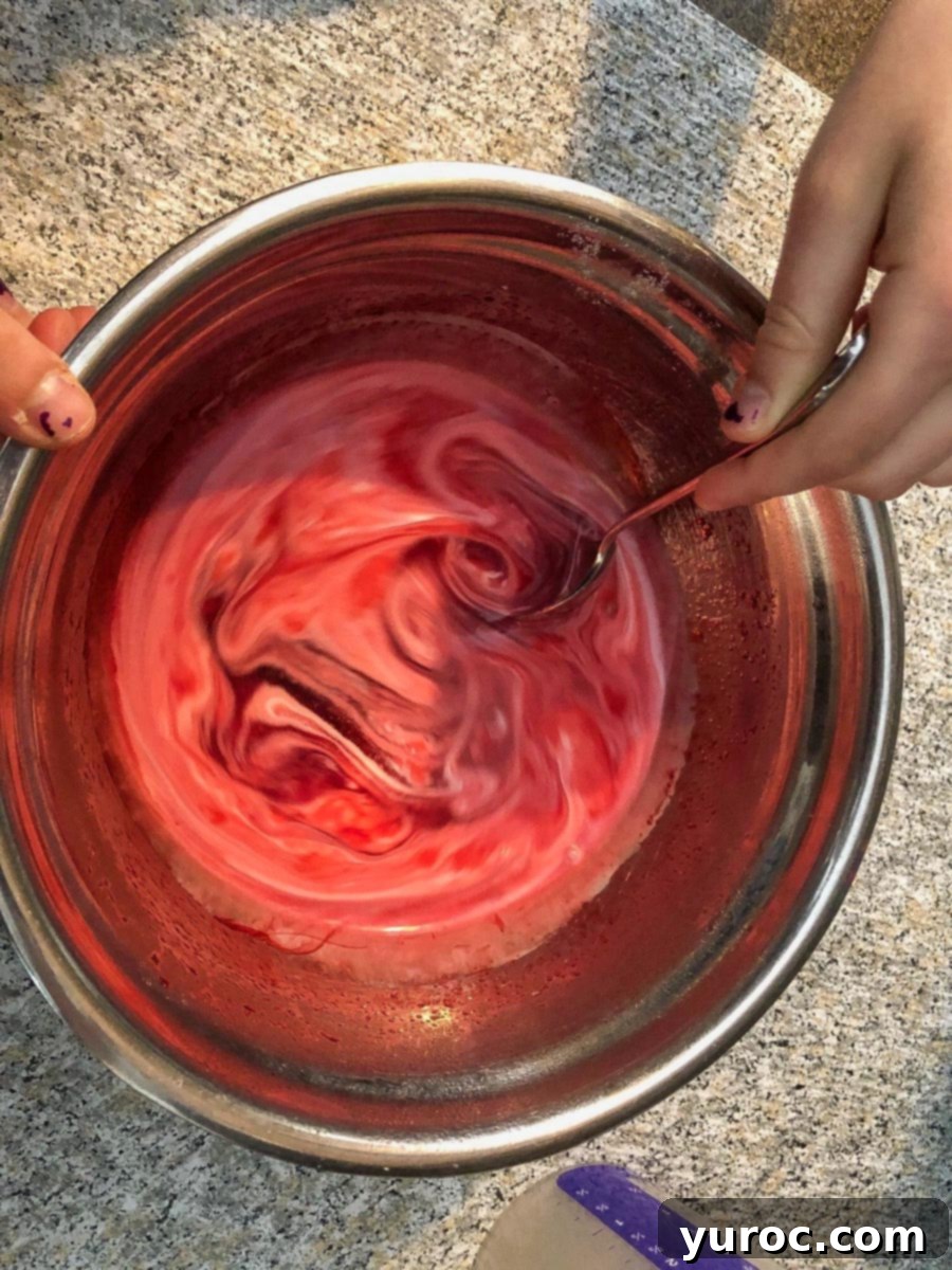 cream and food coloring blended with gelatin mixture in stainless steel bowl