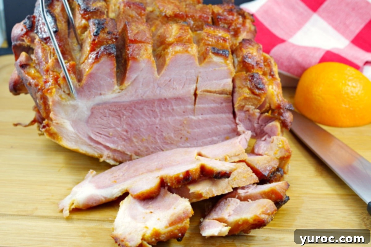 Whole picnic ham with orange glaze, sliced in front