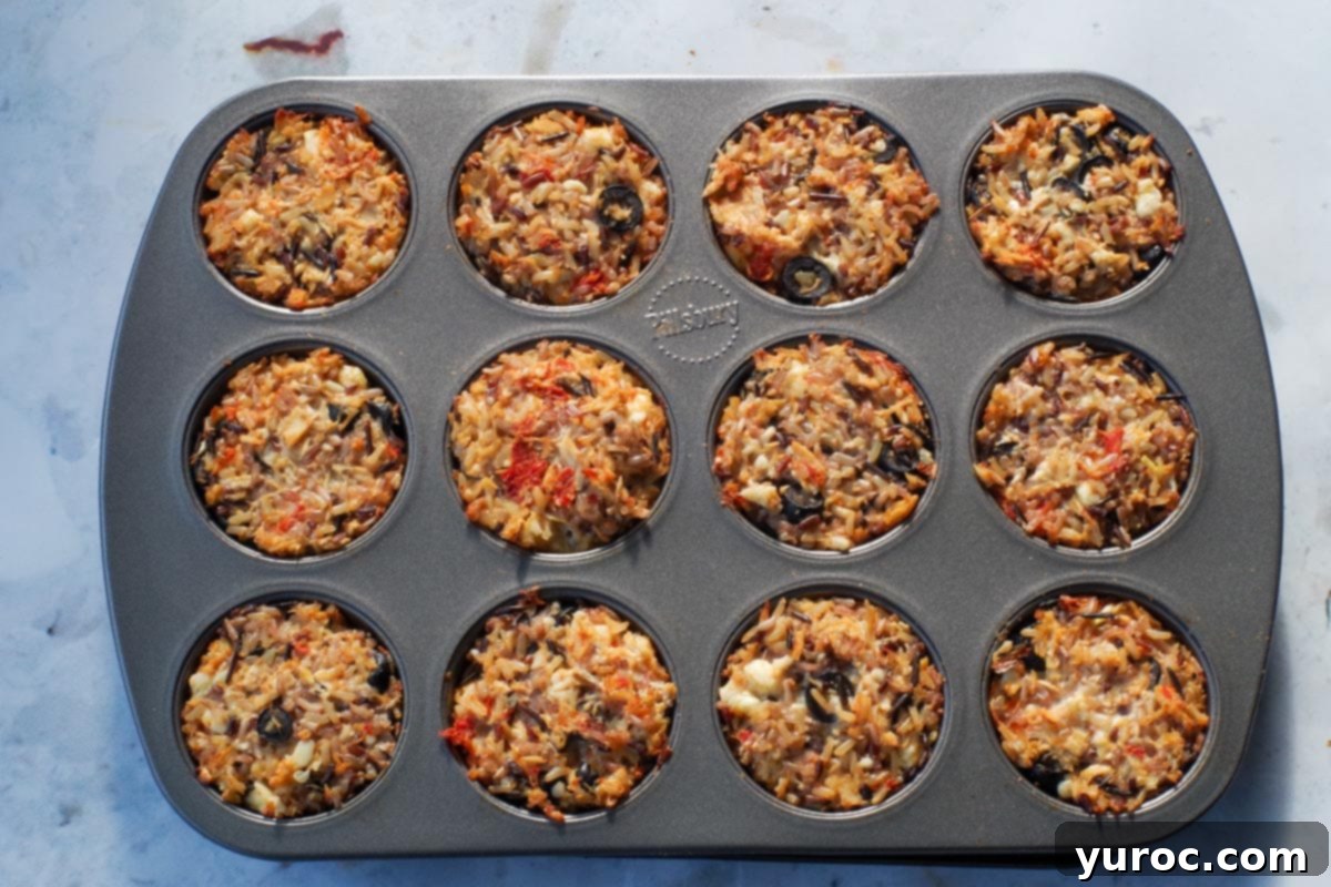 Zesty Mediterranean Chicken Rice Cups 10 Golden brown, cooked rice cups sitting in the muffin tin after baking