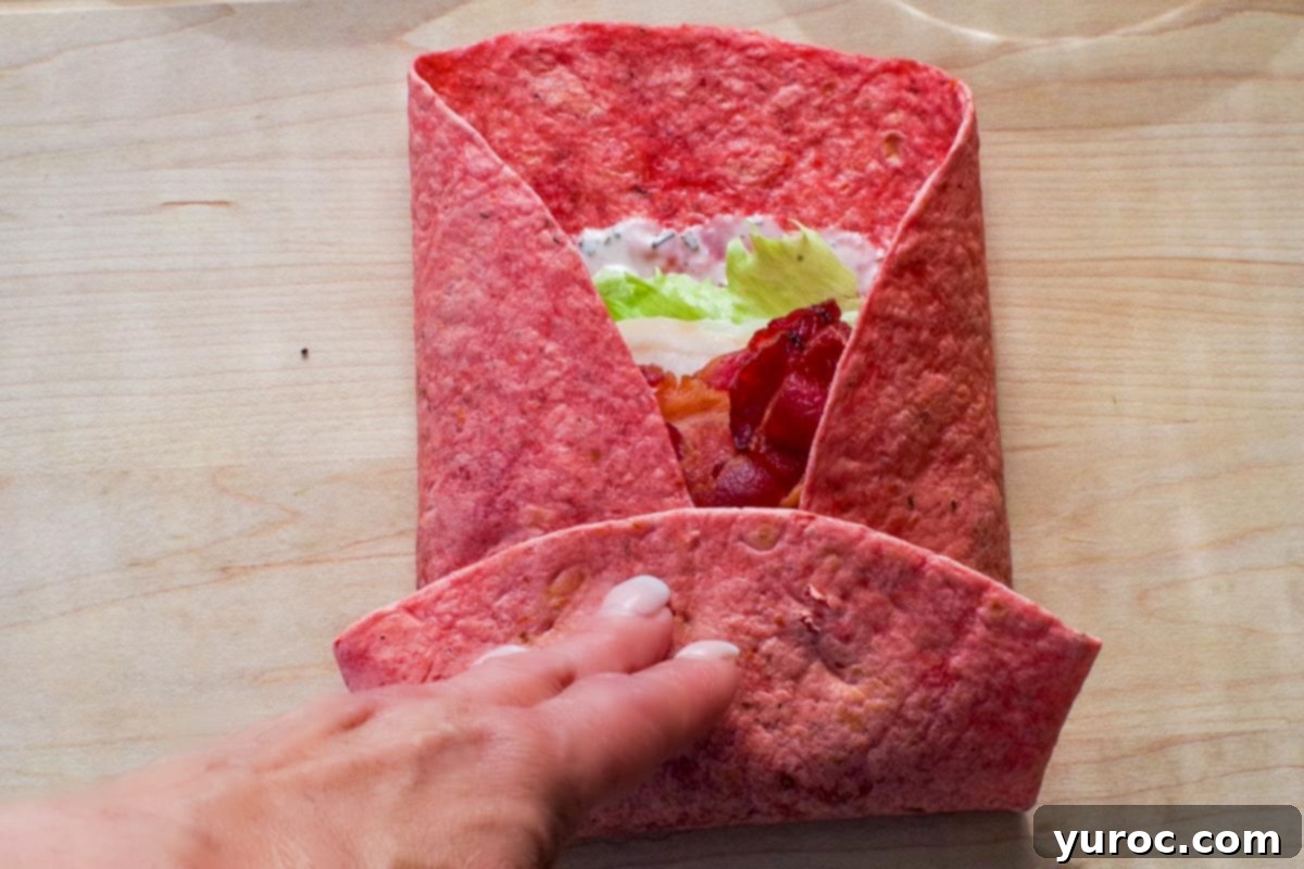 Ultimate Turkey Bacon Ranch Wrap 7 Partially folded wrap, with the sides tucked in and the bottom rolled up, ready for the final roll.