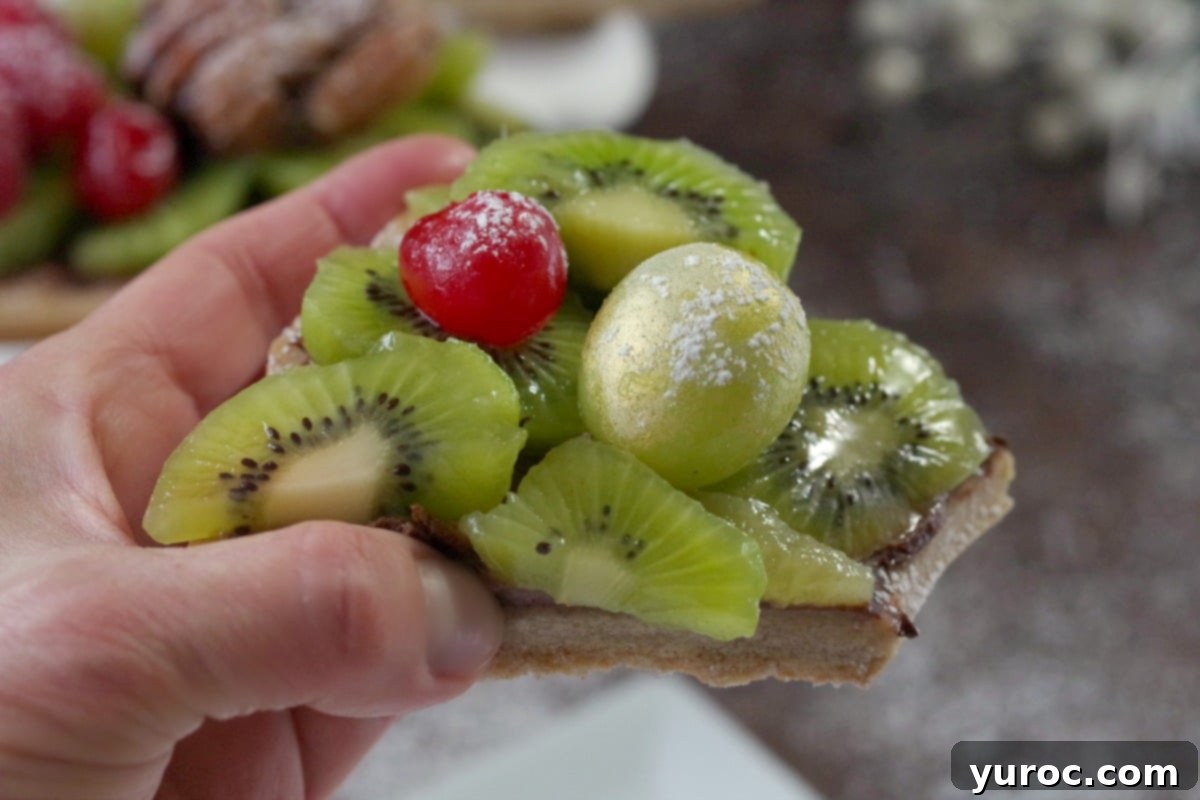 piece of gingerbread cookie fruit wreath being held up and whole wreath in background