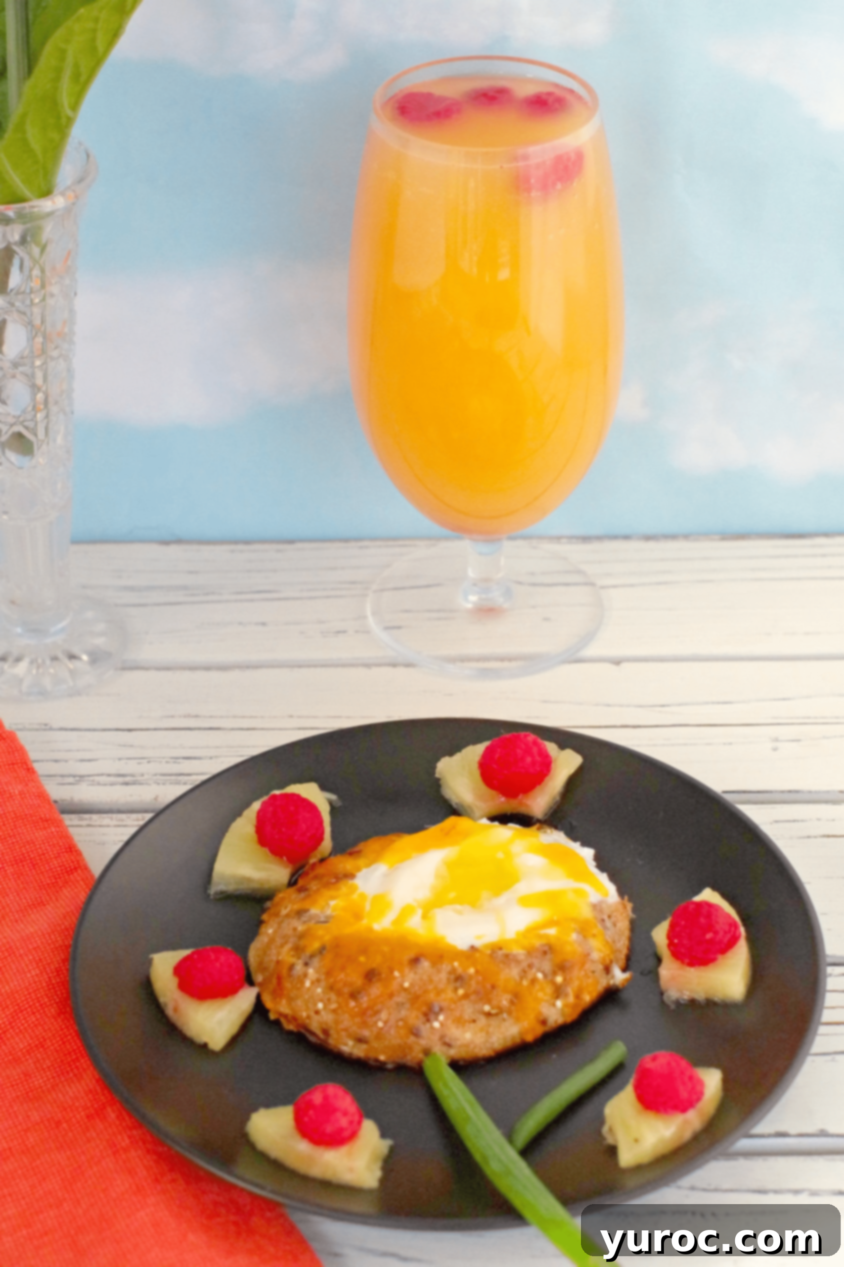 bagel in a hole with mimosa mocktail in background