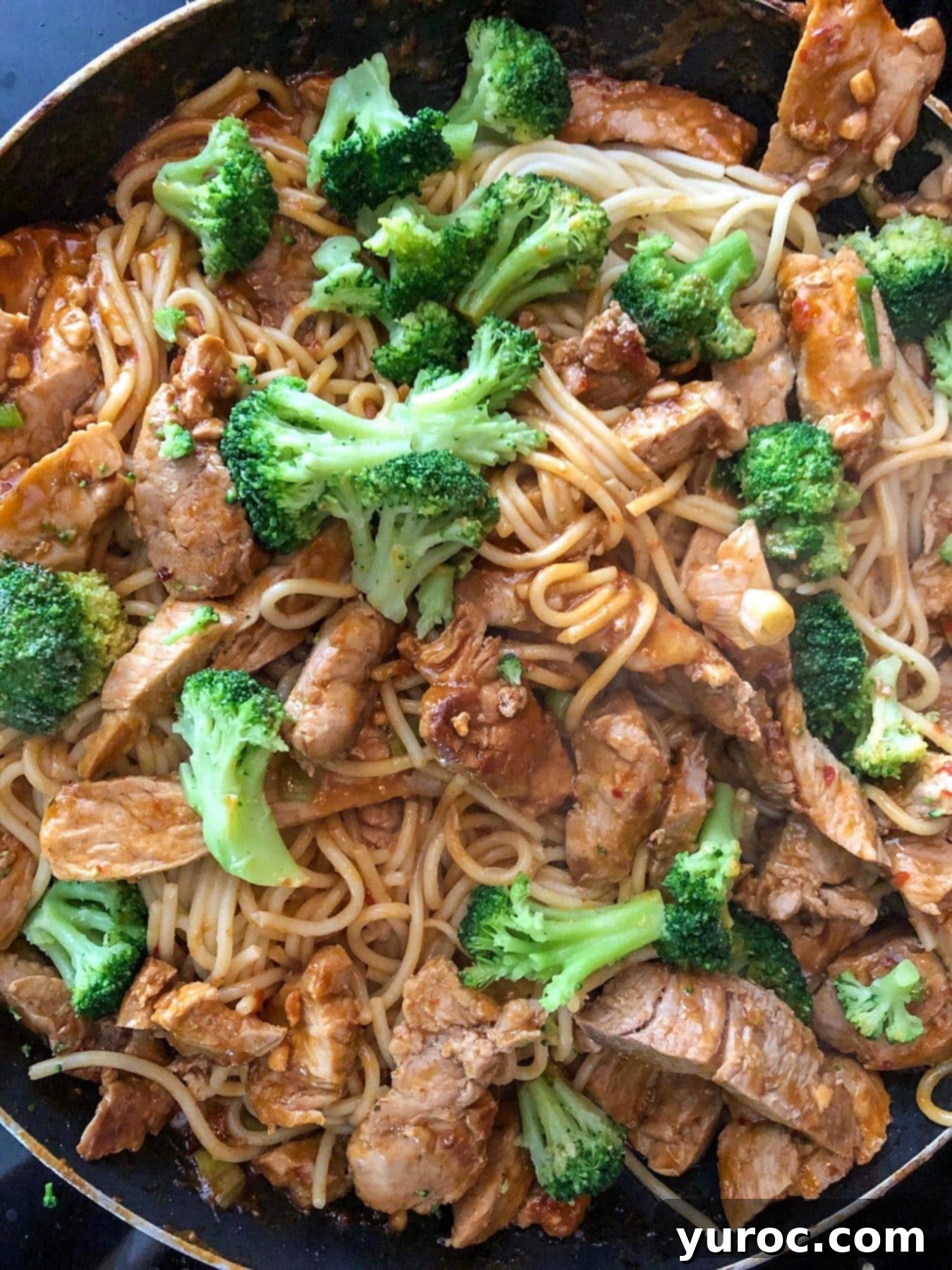 Weeknight Thai Pork Noodles 7 sliced pork with sauce, broccoli, and noodles in a frying pan